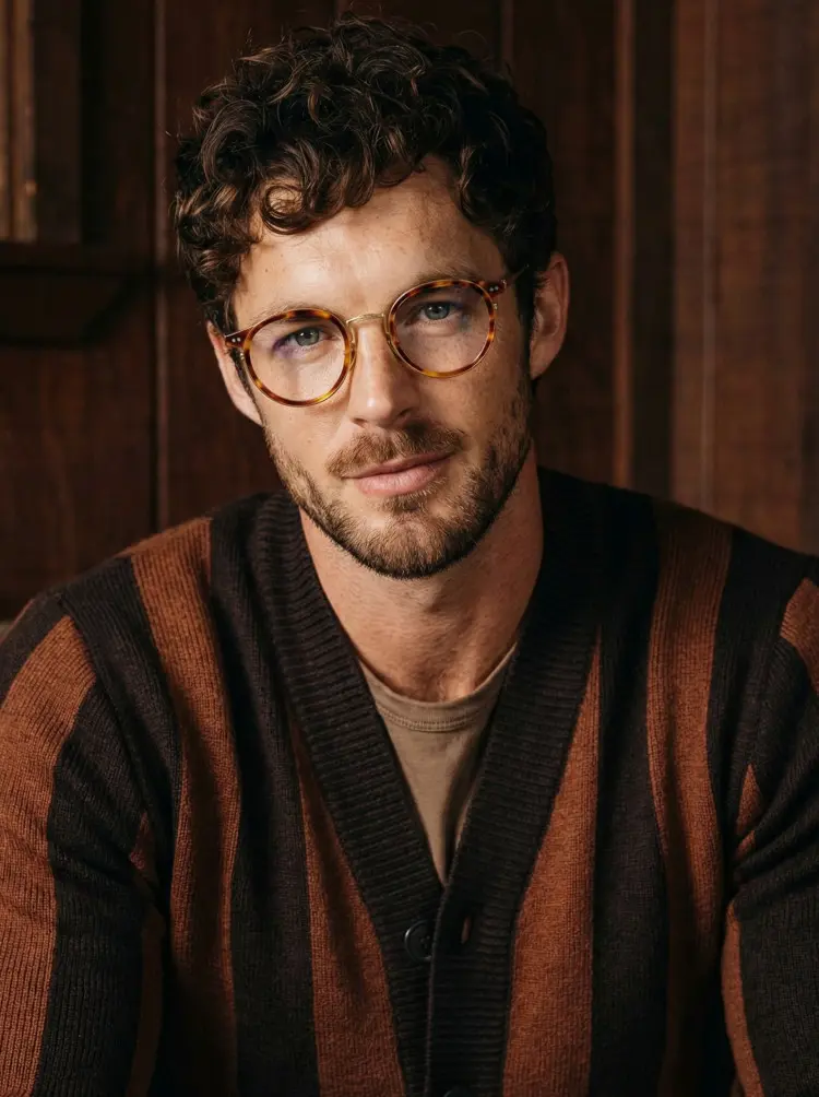 Male model wearing vintage yellow tortoise round titanium eyeglasses in front of a dark wooden wall. SPU: RT0022209