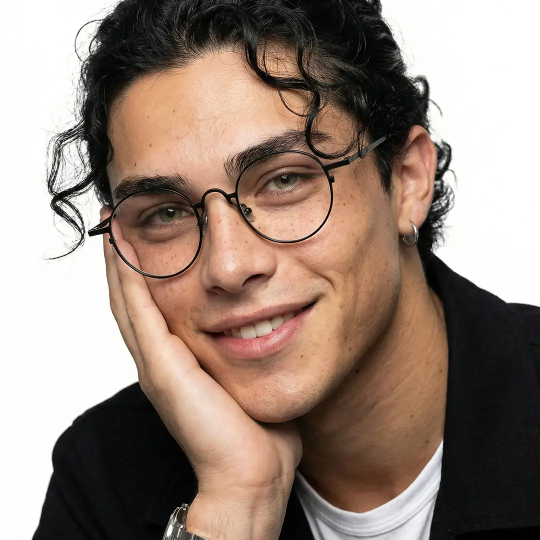 Slightly angled view of male wearing john lennon black round eyeglasses, resting chin on hand, natural smile, RT0042305