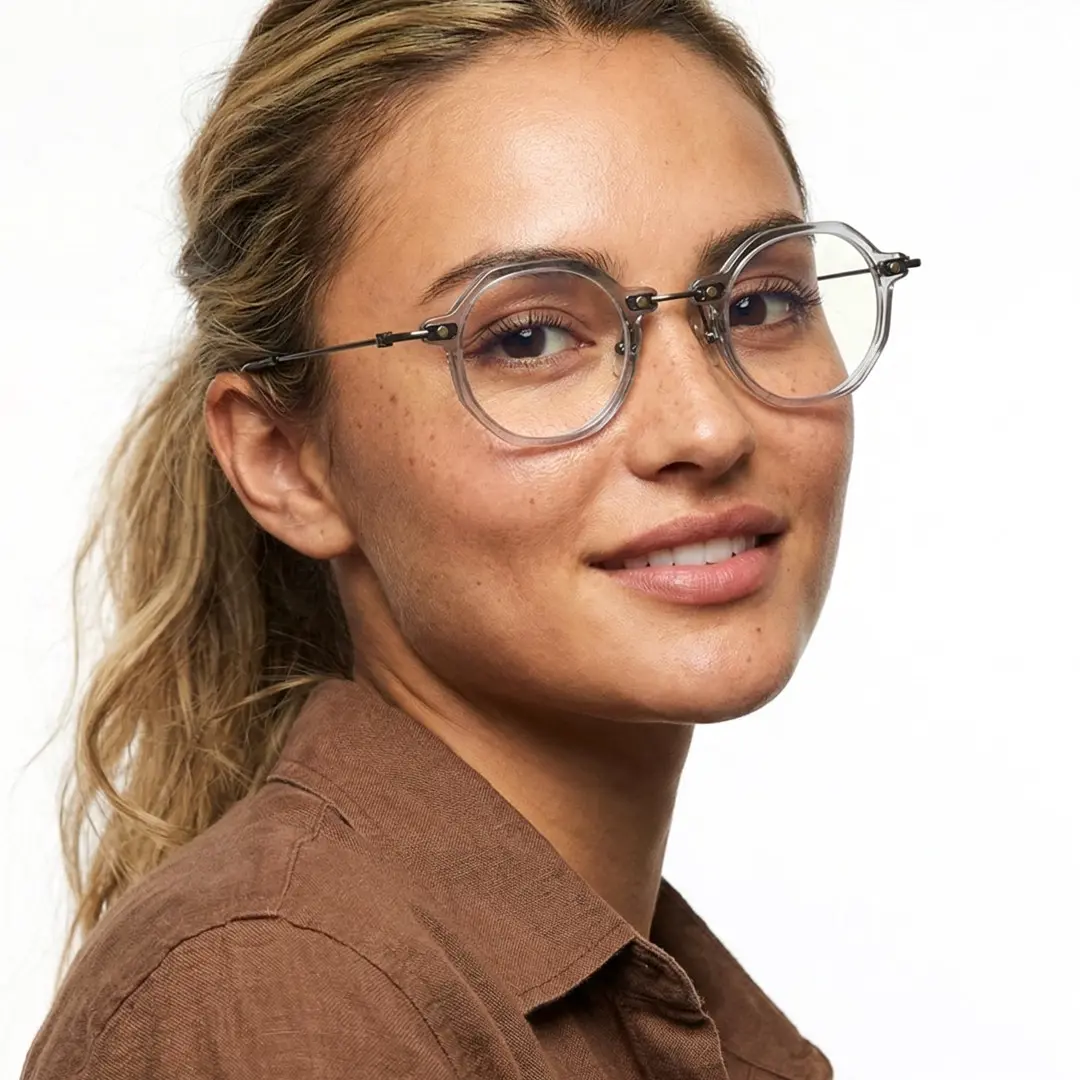 Over-the-shoulder view of female wearing grey round eyeglasses, natural smile, RT0042306