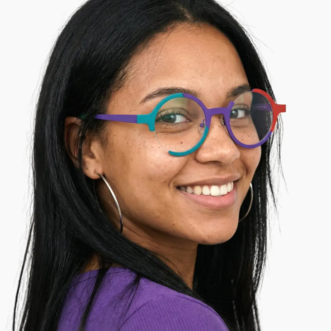 Over-the-shoulder view of female wearing multicolor round eyeglasses, smiling, RT0072407
