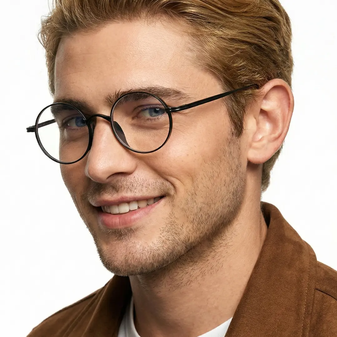 Three-quarter view of male wearing black round eyeglasses, soft smile, RT0172303