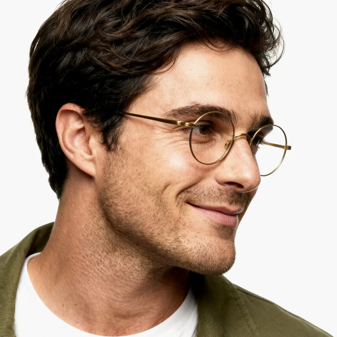 Profile view of male wearing brown round eyeglasses, natural smile, RT0172303