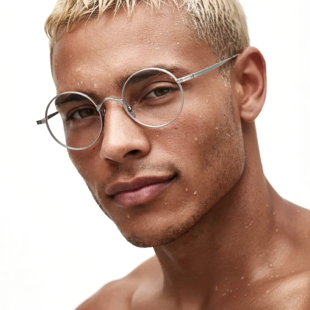 Three-quarter view of male wearing silver round eyeglasses, natural expression, RT0172303