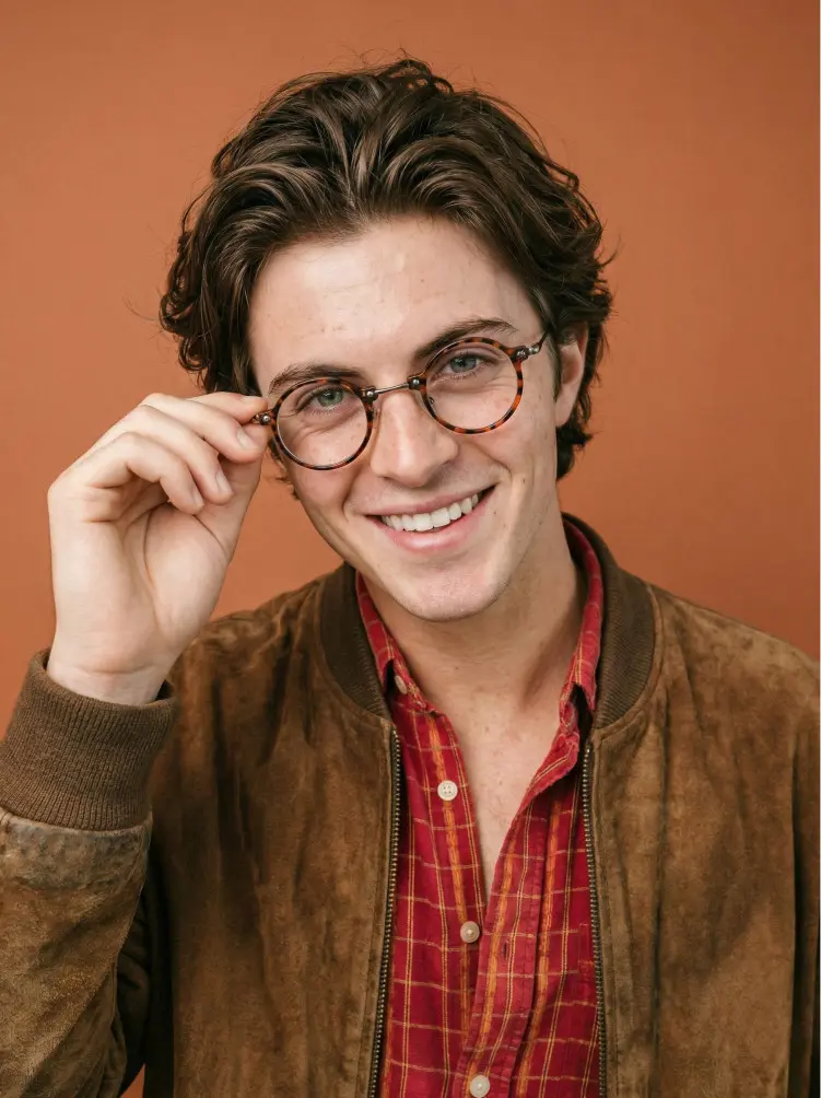 Male model wearing vintage tortoise round metal eyeglasses in a studio with a warm brown background. SPU: RT0302405