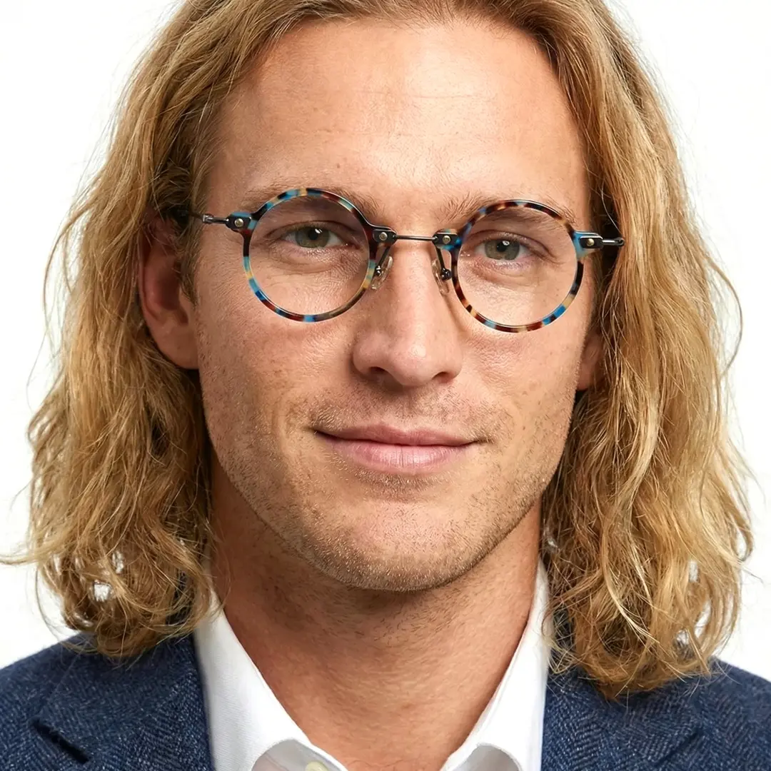 Front view of male wearing blue tortoise round eyeglasses, smiling, RT0302406