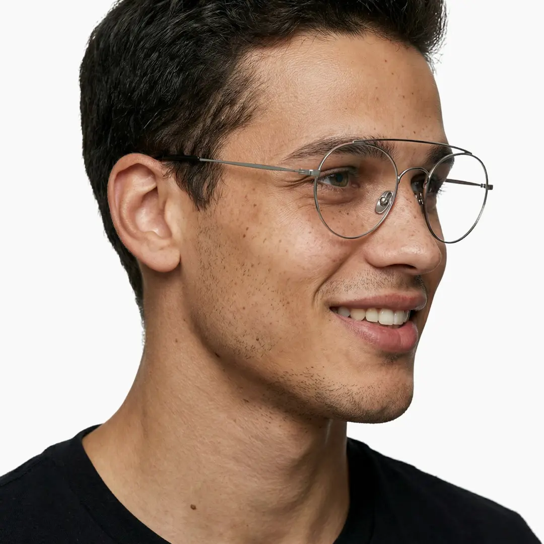 Looking away view of male wearing silver round eyeglasses, natural smile, RT0912508