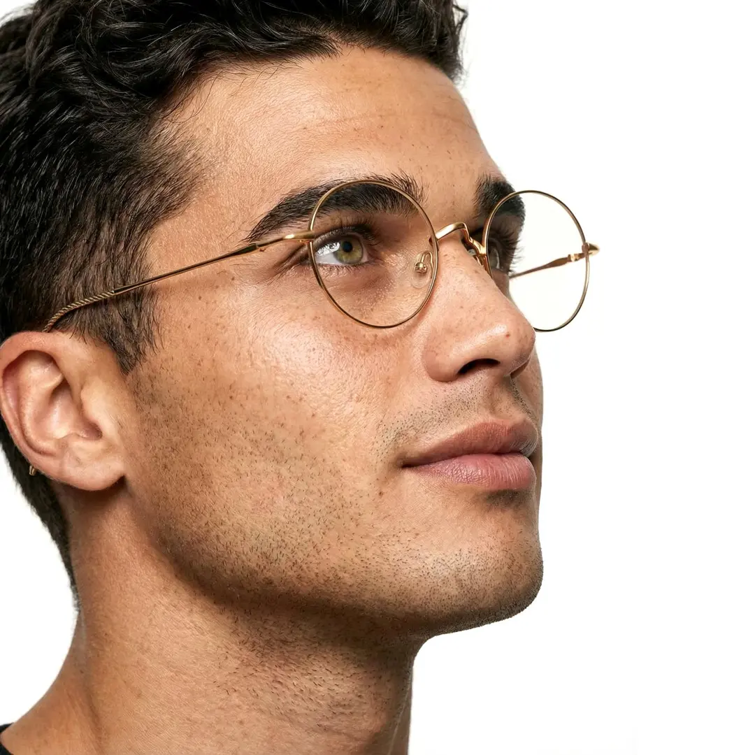 Profile view of male wearing gold round eyeglasses, natural smile, RT0942508