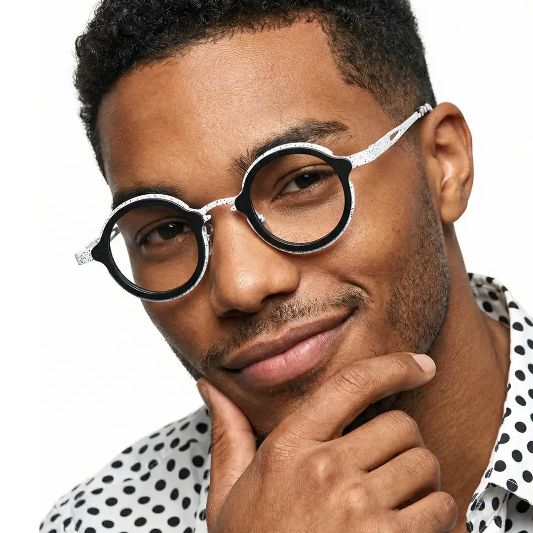 Three-quarter view of male wearing black round eyeglasses, resting chin on hand, natural smile, RT0962508