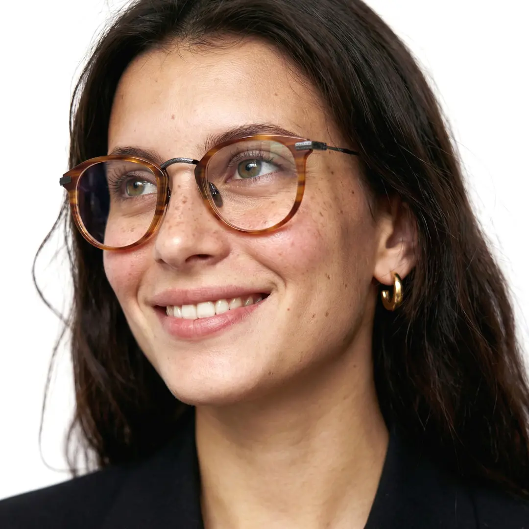 Looking away view of female wearing vintage tortoise round eyeglasses, smiling, RX0062207