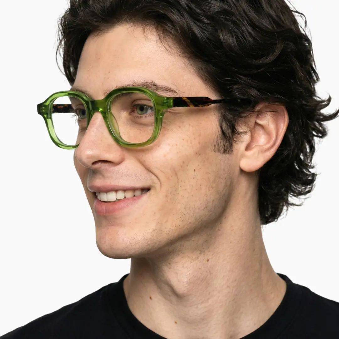 Profile view of male wearing green square eyeglasses, smiling, SA0052312