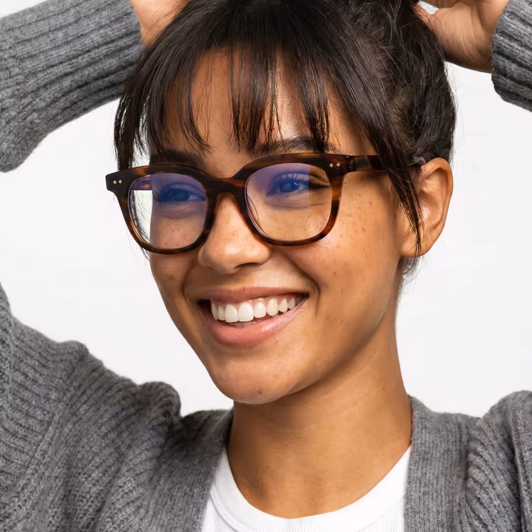 Female wearing brown tortoise square acetate eyeglasses, smiling while placing hand on forehead. SPU: SA0102401