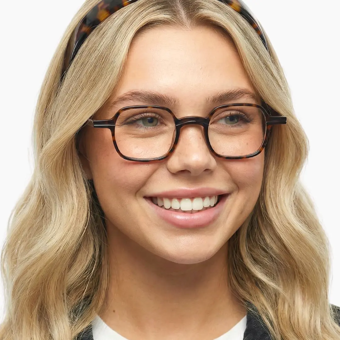 Three-quarter view of female wearing vintage tortoise square eyeglasses, natural smile, SA0112302