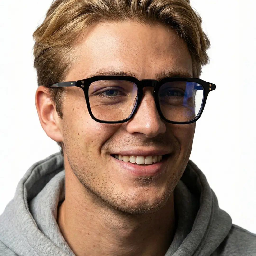 Three-quarter view of male wearing black square eyeglasses, natural smile, SA0192403
