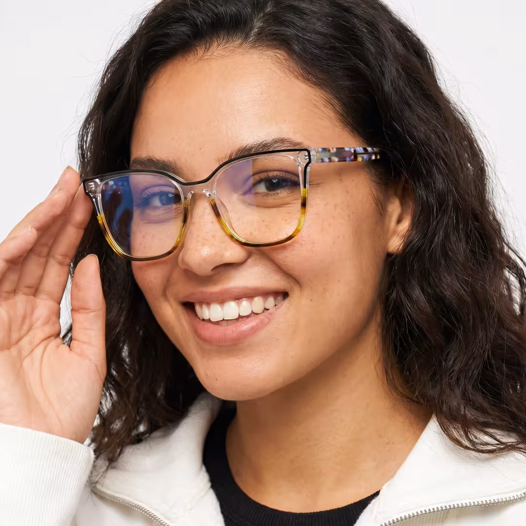 Female wearing colorful blue tortoise square acetate eyeglasses, smiling while touching frame. SPU: SA0382605