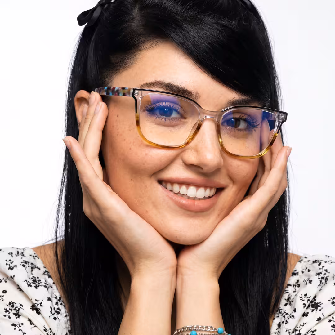 Female wearing colorful blue tortoise square acetate eyeglasses, smiling while resting chin on hand. SPU: SA0382605
