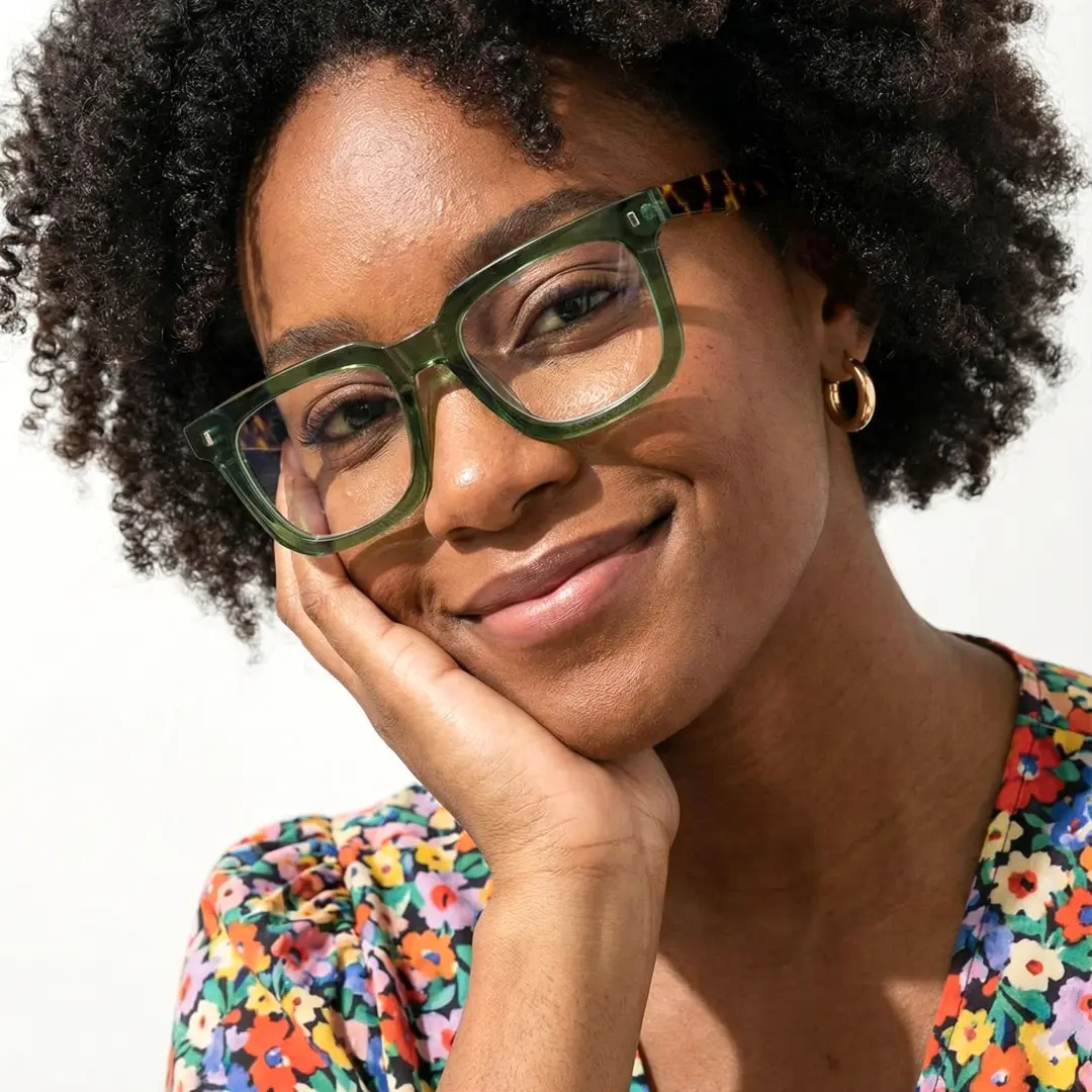 Tilted head view of female wearing green square eyeglasses, hand near face, natural expression, SA0412504