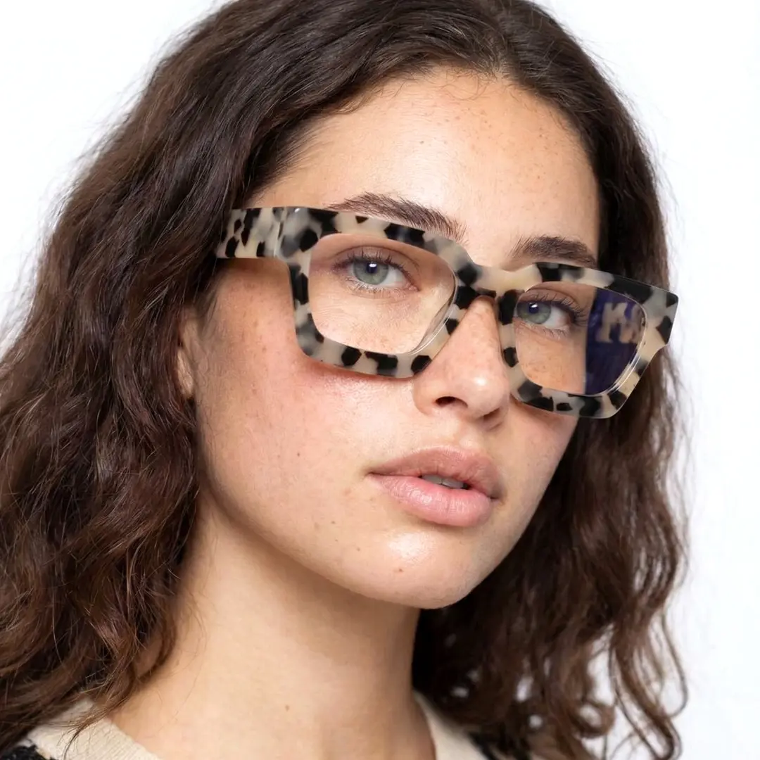 Slightly angled view of female wearing brown tortoise square eyeglasses, natural expression, SA0552302