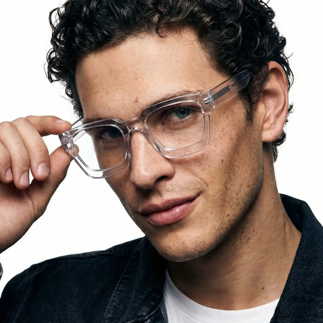 Tilted head view of male wearing clear square eyeglasses, holding glasses, natural smile, SA0552302