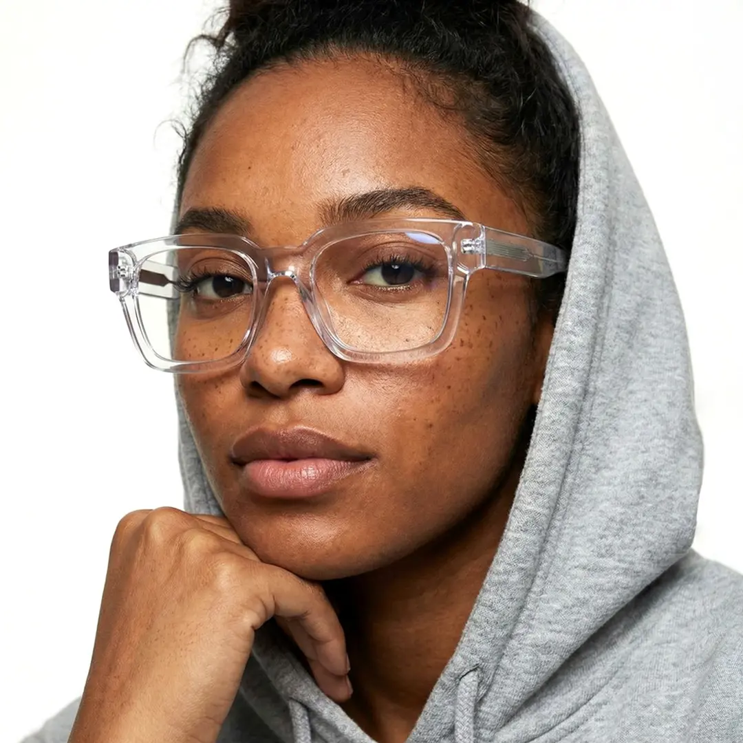 Slightly angled view of female wearing clear square eyeglasses, resting chin on hand, neutral expression, SA0552302