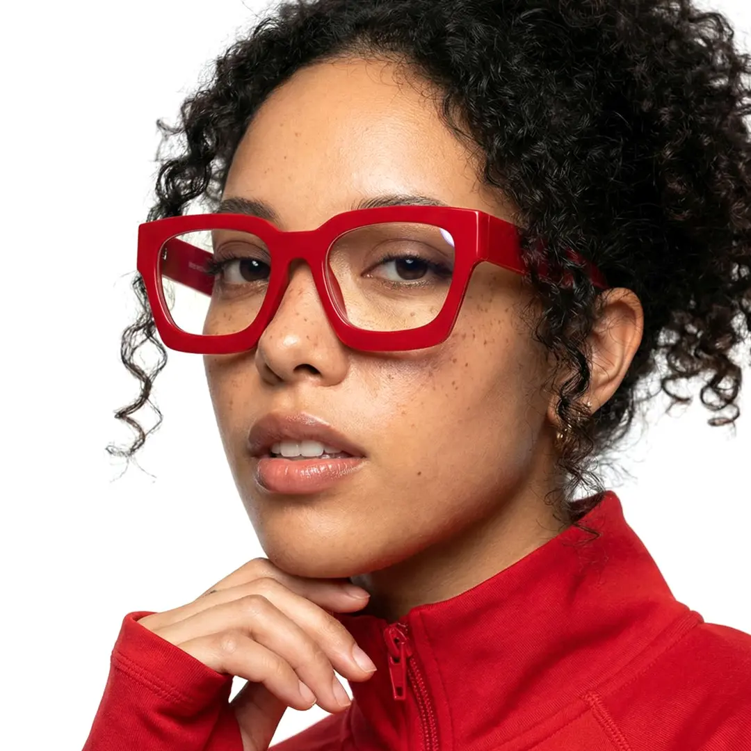 Face close-up view of female wearing red square eyeglasses, resting chin on hand, natural expression, SA0552302