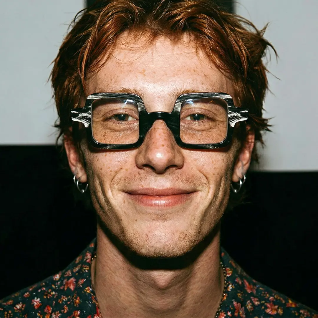 Front view of male wearing black square eyeglasses, natural smile, SO0032601