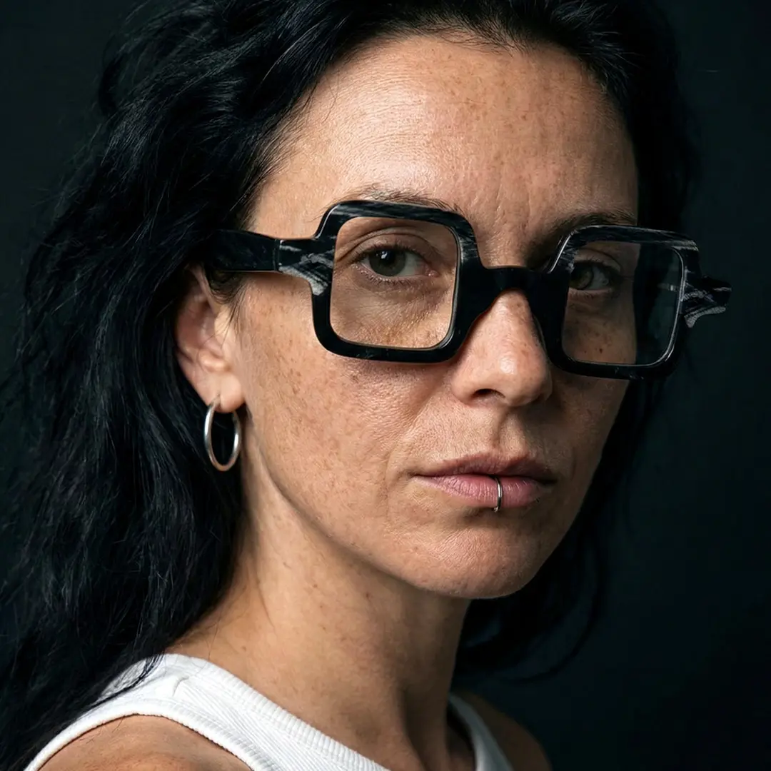 Over-the-shoulder view of female wearing black square eyeglasses, calm expression, SO0032601