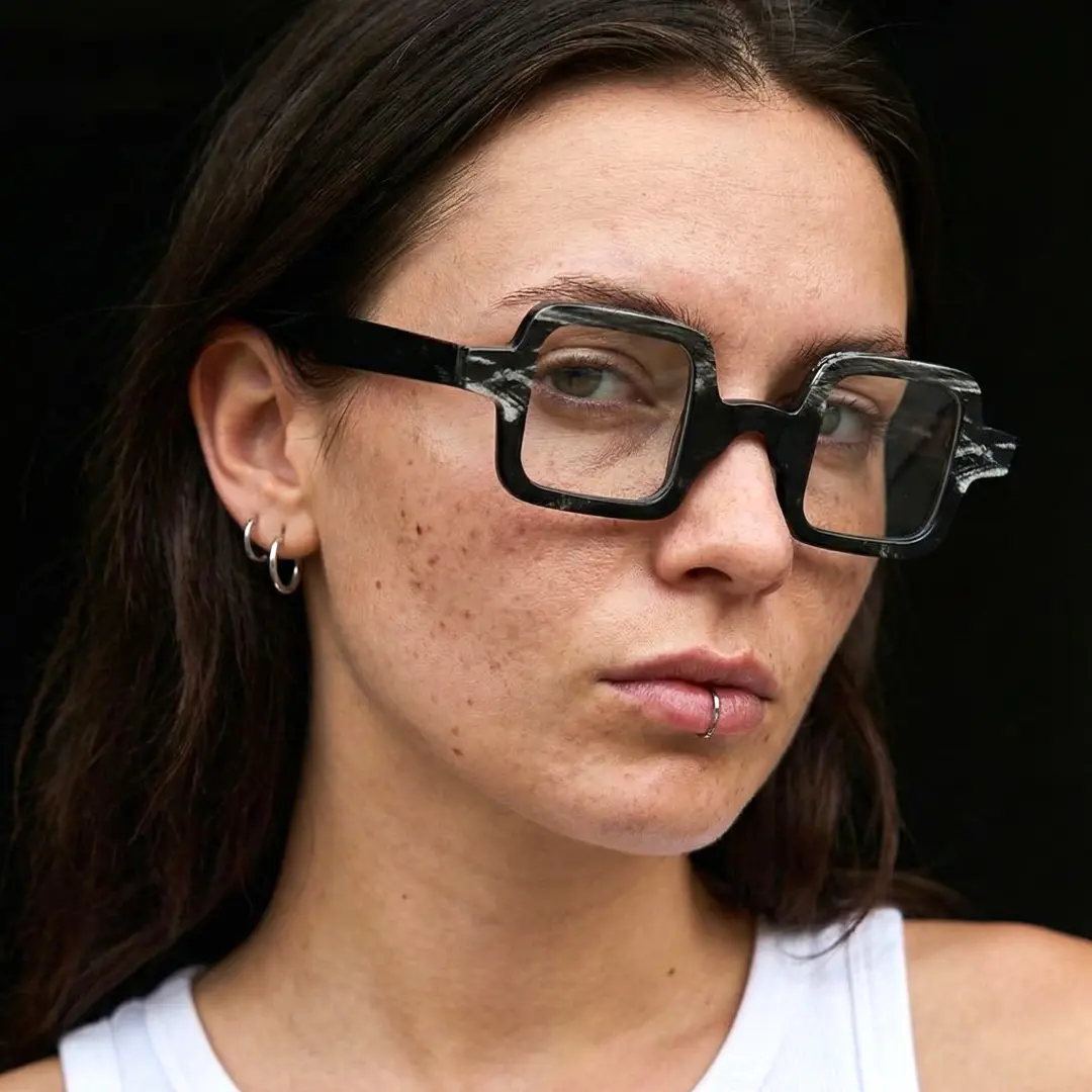 Three-quarter view of female wearing black square eyeglasses, calm expression, SO0032601