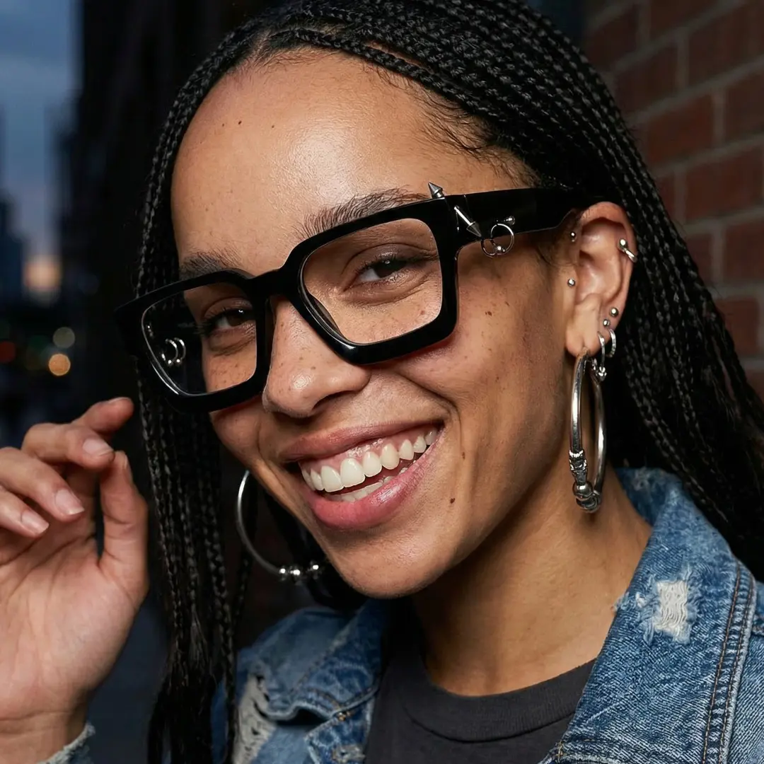 Front view of female wearing black square handcrafted polarized eyeglasses, touching frame, friendly smile, SP0012511