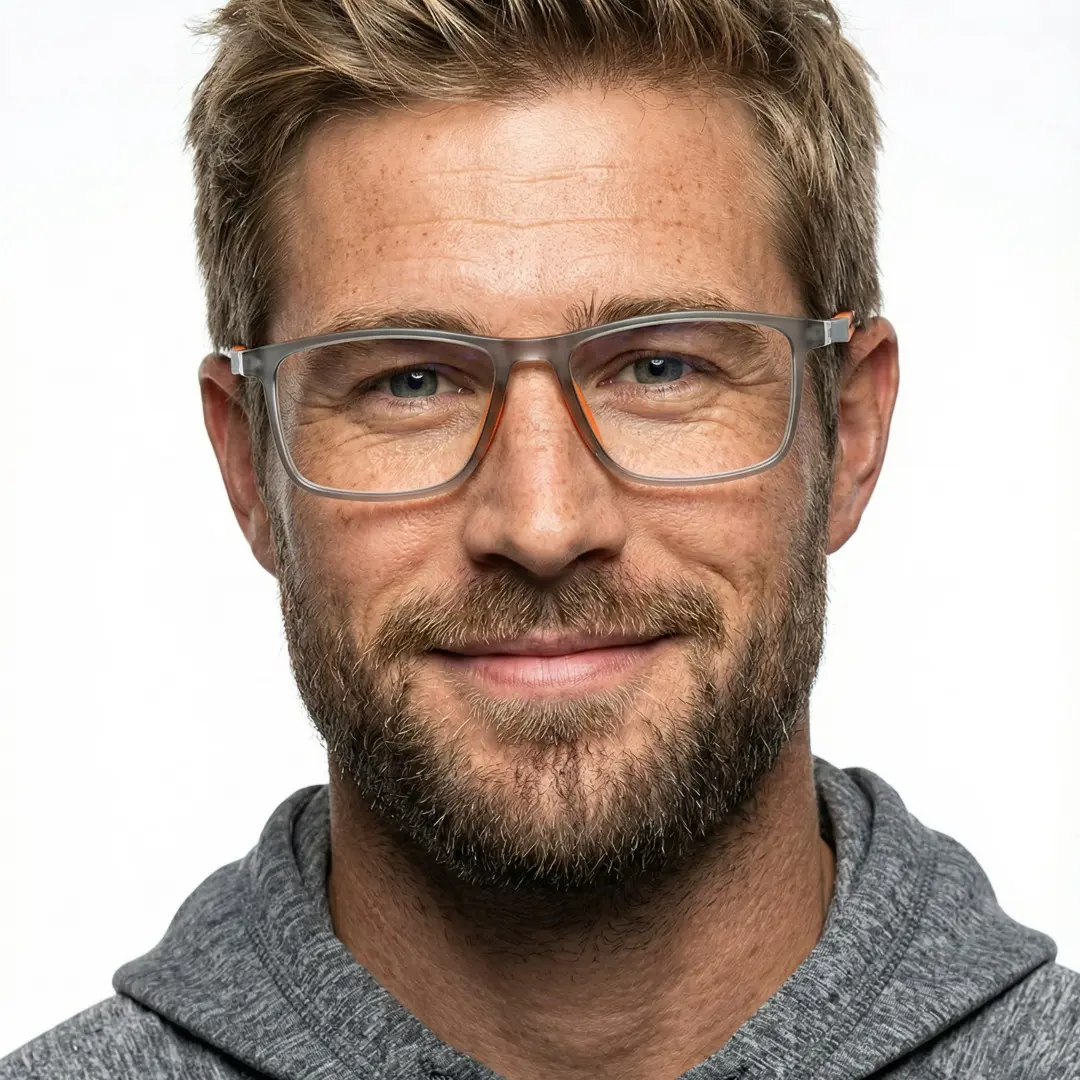 Front view of male wearing orange square eyeglasses, natural smile, SP0042503