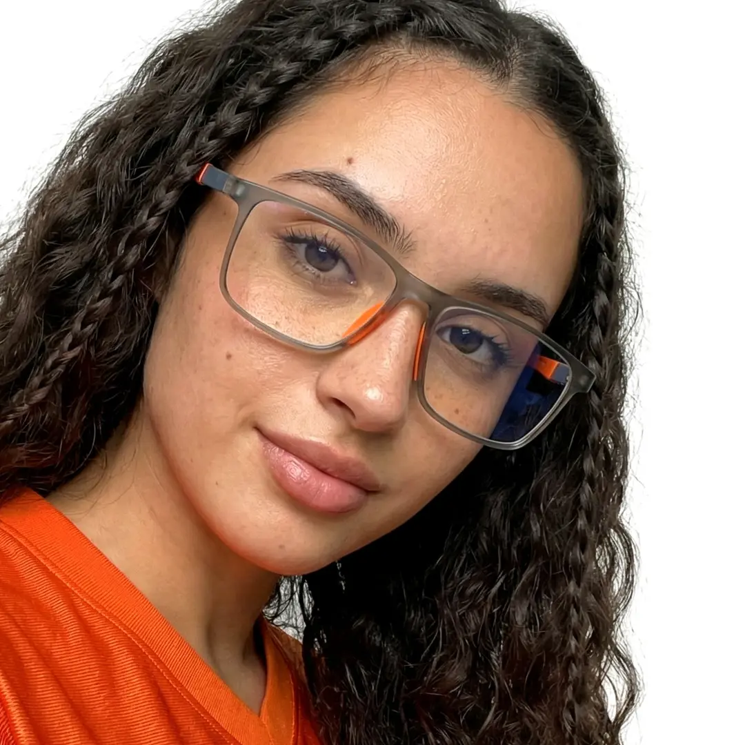 Tilted head view of female wearing orange square eyeglasses, soft smile, SP0042503
