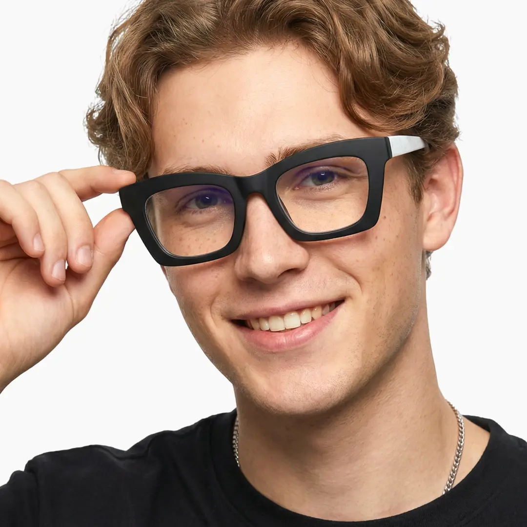 Tilted head view of male wearing white square eyeglasses, holding glasses, natural smile, SP0082408