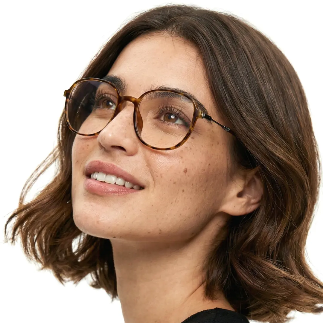 Looking away view of female wearing tortoise square eyeglasses, smiling, SR0012411