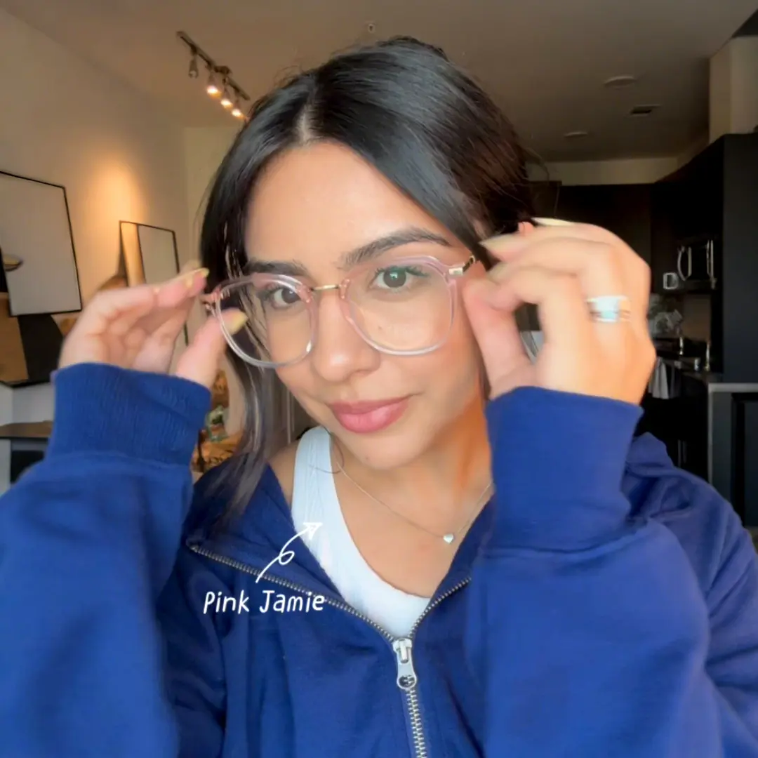 Front view of female wearing pink square eyeglasses, touching frame, neutral expression, SR0012502