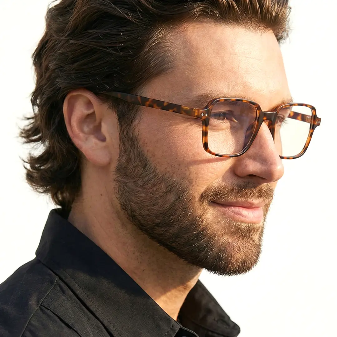 Three-quarter view of male wearing tortoise square eyeglasses, natural smile, SR0022508