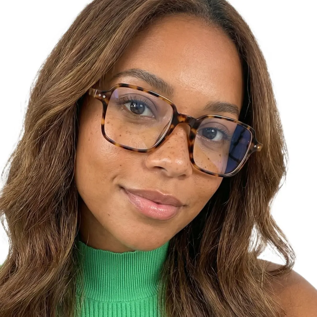 Front view of female wearing tortoise square eyeglasses, tilting head, friendly smile, SR0022508