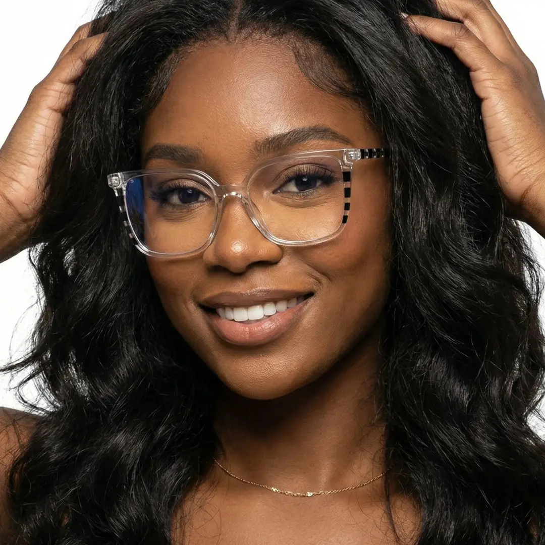 Front view of female wearing clear square eyeglasses, hand in hair, smiling, SR0022510