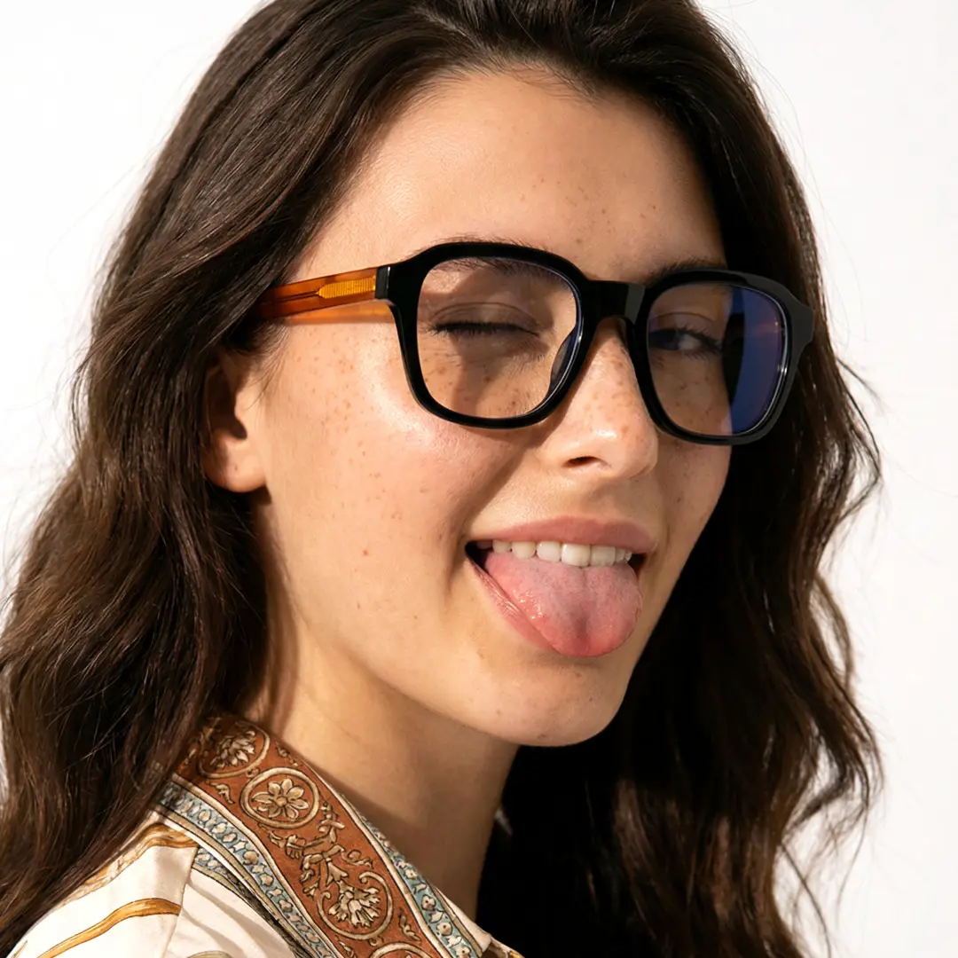 Three-quarter view of female wearing two tone square eyeglasses, sticking out tongue, SR0032508