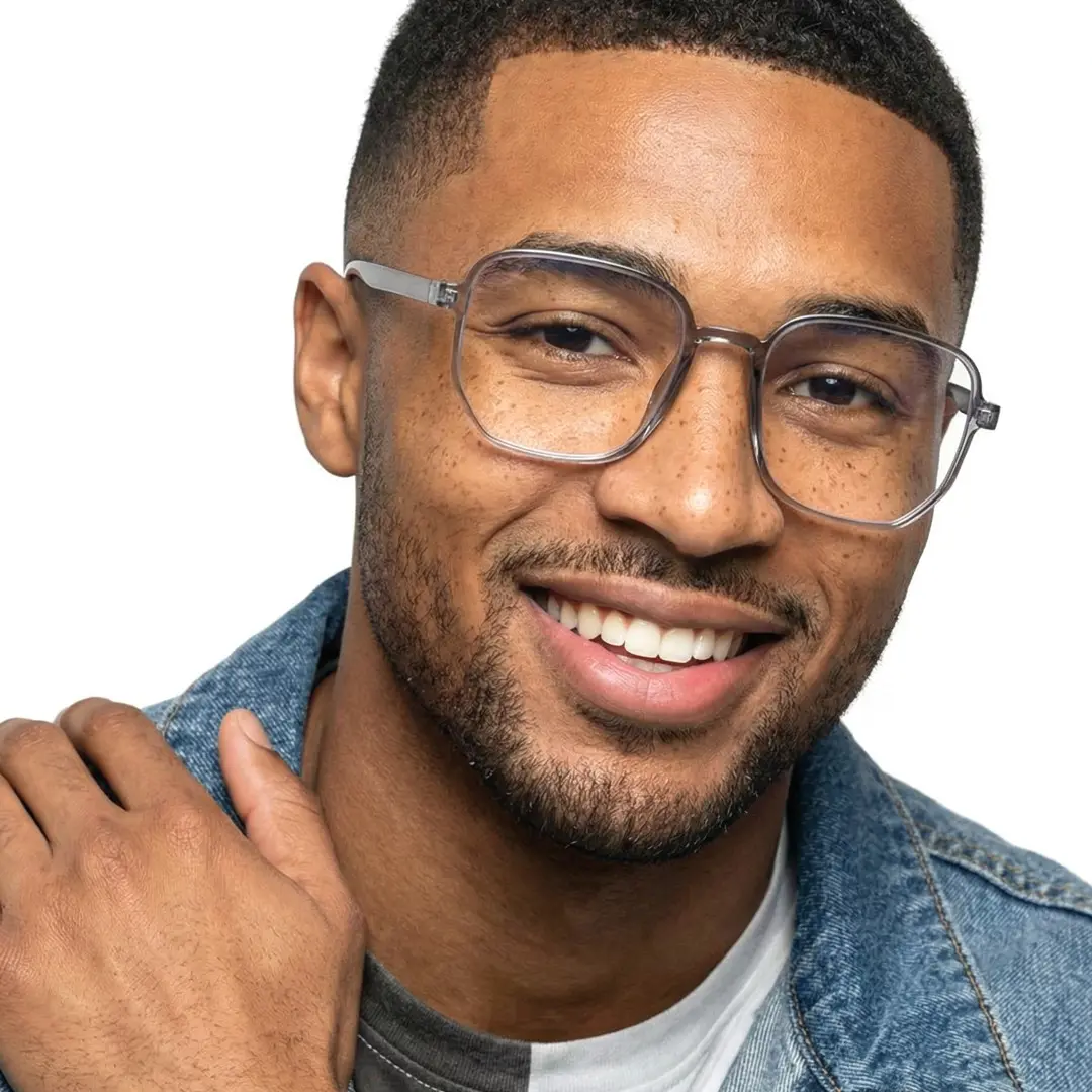 Tilted head view of male wearing grey square eyeglasses, hand resting on forehead, smiling, SR0052410