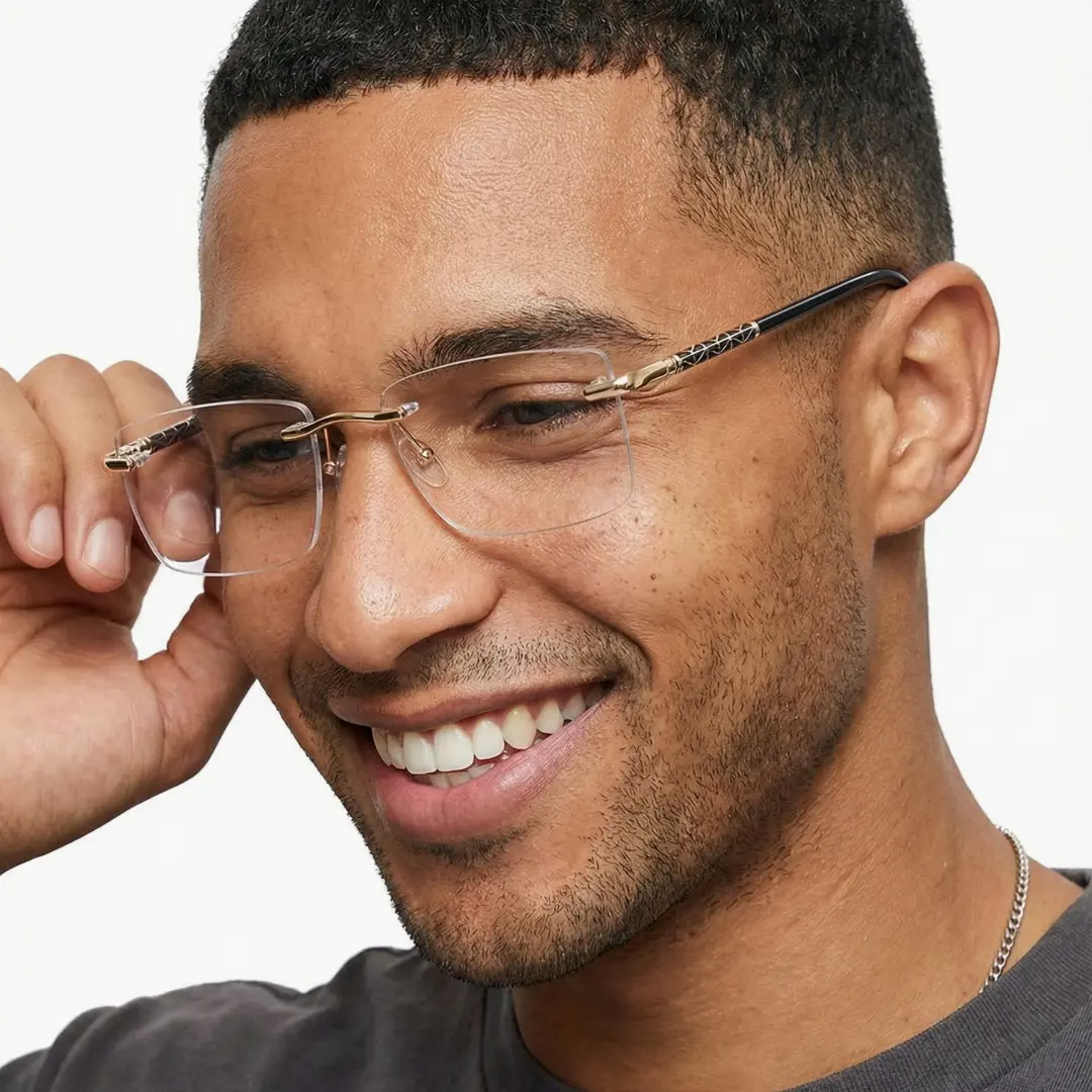Three-quarter view of male wearing black rectangle eyeglasses, touching frame, smiling, SX0152507