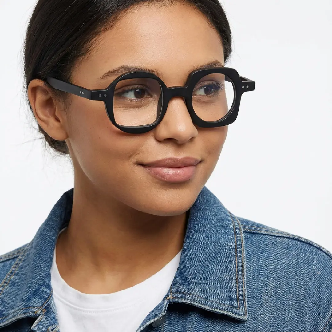 Three-quarter view of female wearing black unique eyeglasses, natural smile, UA0012302