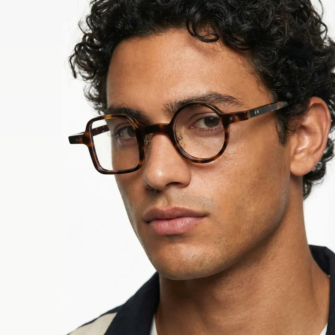 Profile view of male wearing vintage tortoise unique eyeglasses, relaxed expression, UA0042001