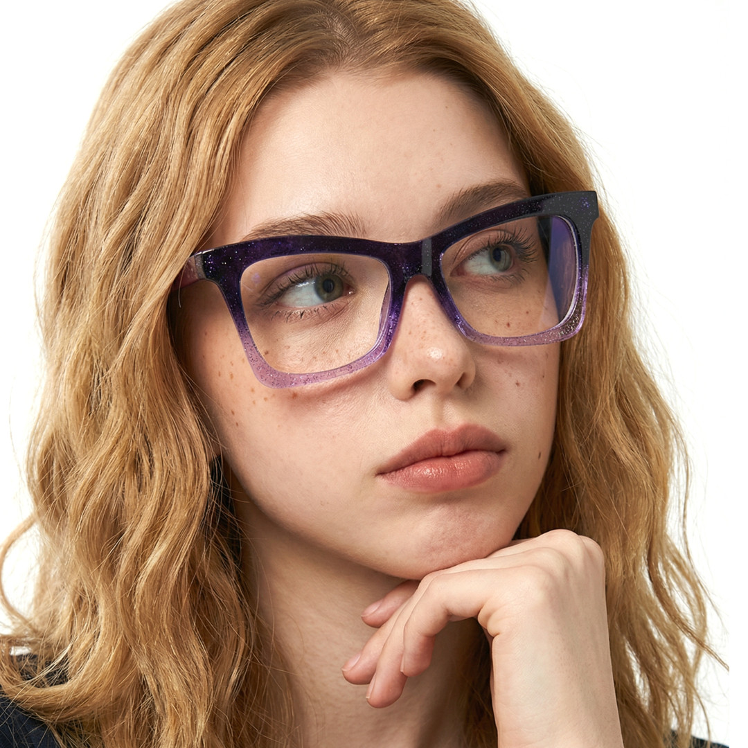 Looking away view of female wearing purple butterfly eyeglasses, resting chin on hand, neutral expression, UR0152502