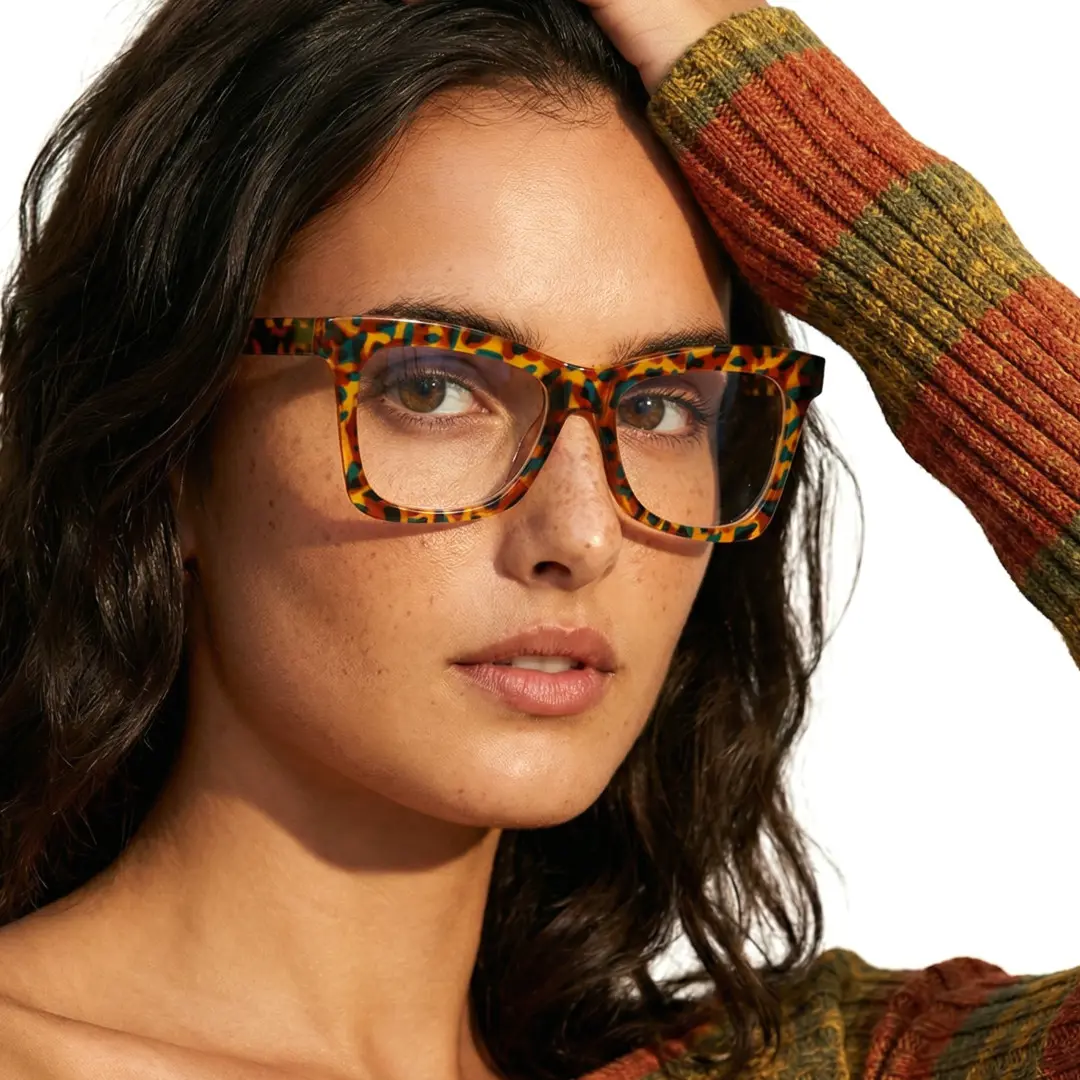 Face close-up view of female wearing tortoise butterfly eyeglasses, hand in hair, natural expression, UR0152502
