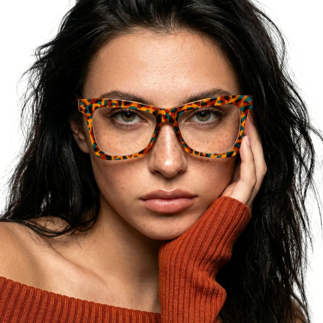 Front view of female wearing tortoise butterfly eyeglasses, resting chin on hand, calm expression, UR0152502