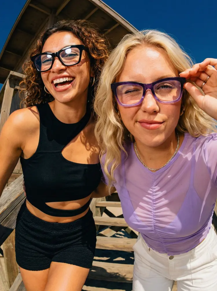Two people wearing fashion black and tortoise butterfly tr90 eyeglassesat a sunny beach lifeguard tower. SPU: UR0152502