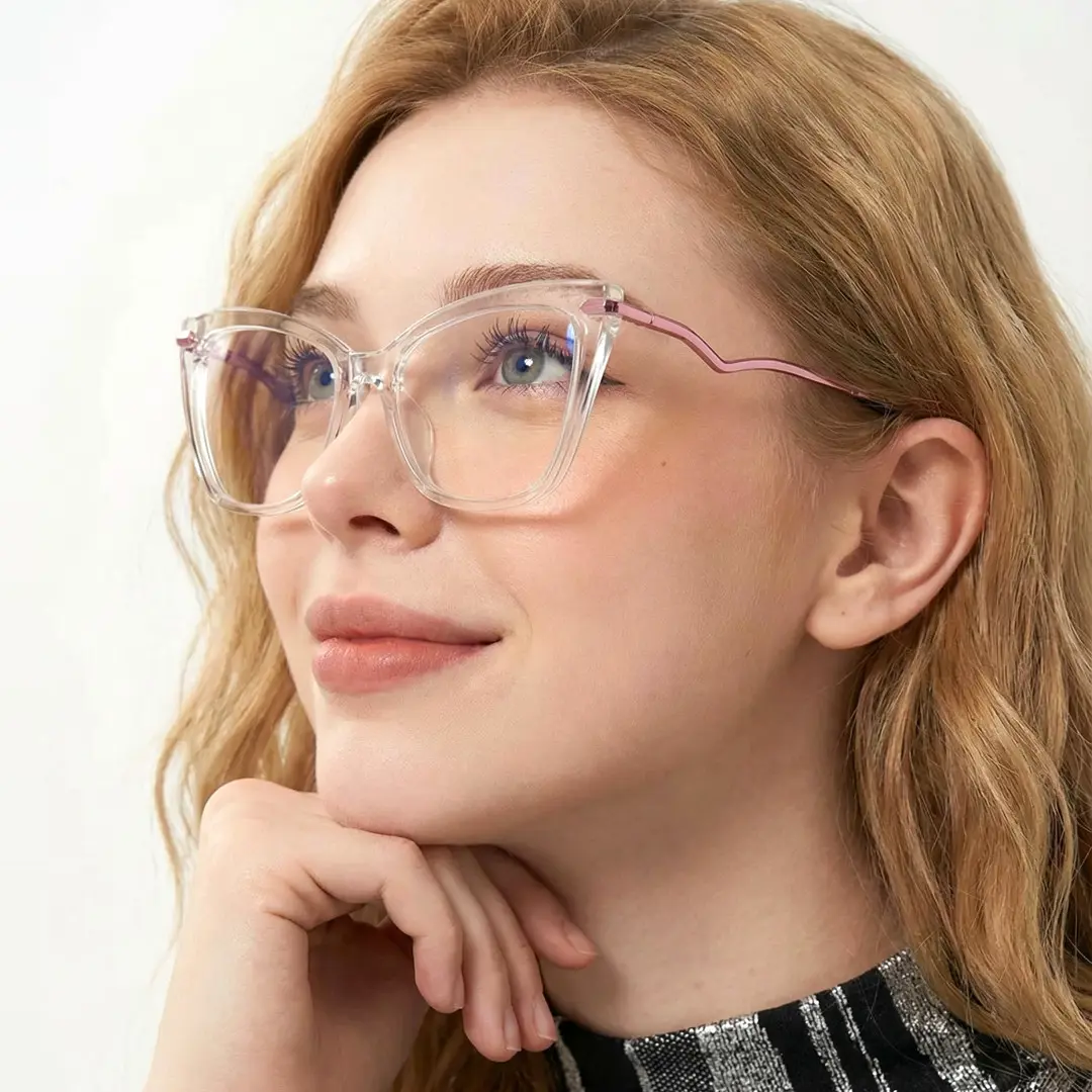 Looking away view of female wearing clear butterfly eyeglasses, resting chin on hand, soft smile, UR0172502
