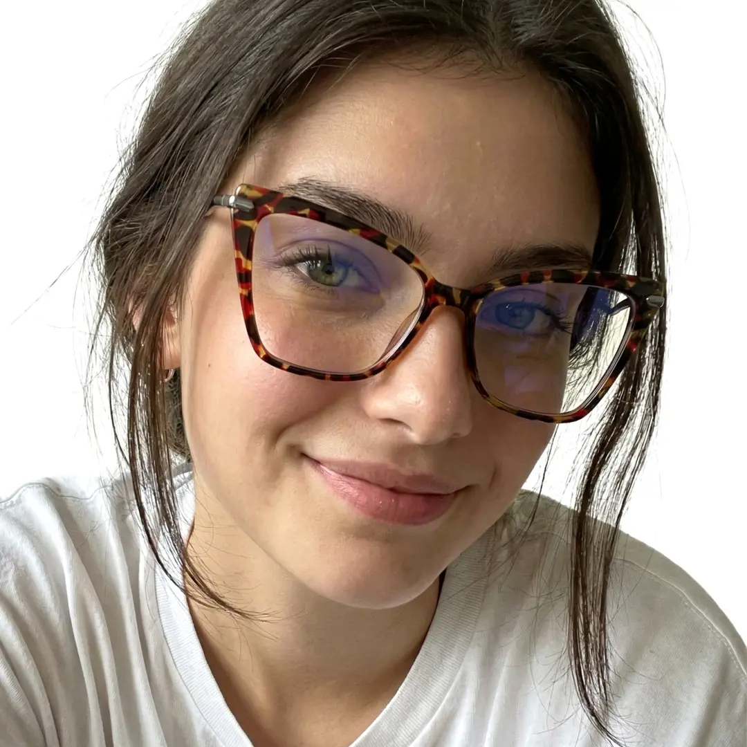 Face close-up view of female wearing tortoise butterfly eyeglasses, soft smile, UR0172502
