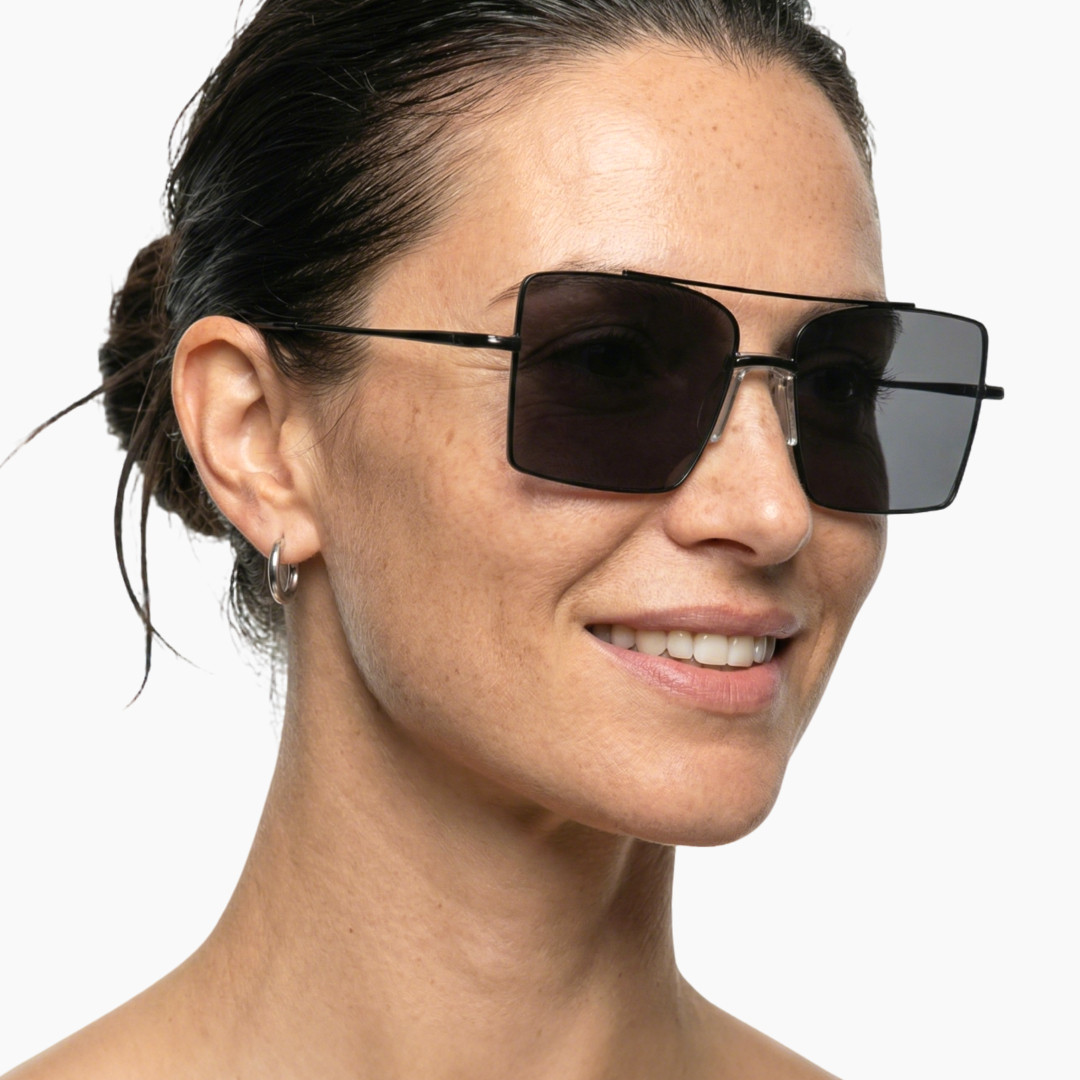 Looking away view of female wearing grey aviator sunglasses, smiling, AM0072505