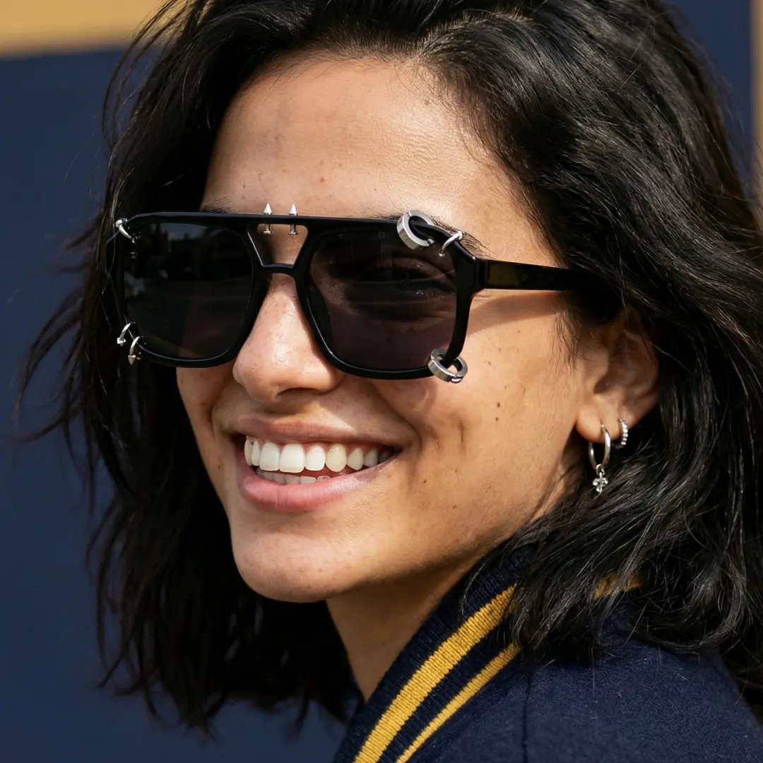 Over the shoulder view of female wearing black aviator handcrafted polarized sunglasses, wide smile, AP0052511