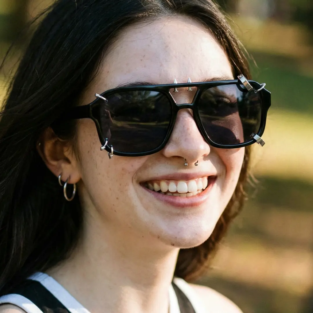 Three-quarter view of female wearing black aviator handcrafted polarized sunglasses, natural smile, AP0052511